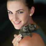 Cropped portrait of an attractive young woman posing with two pigmy marmosets